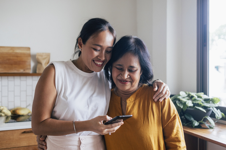 Daughter and elderly mother discussing life insurance needs.