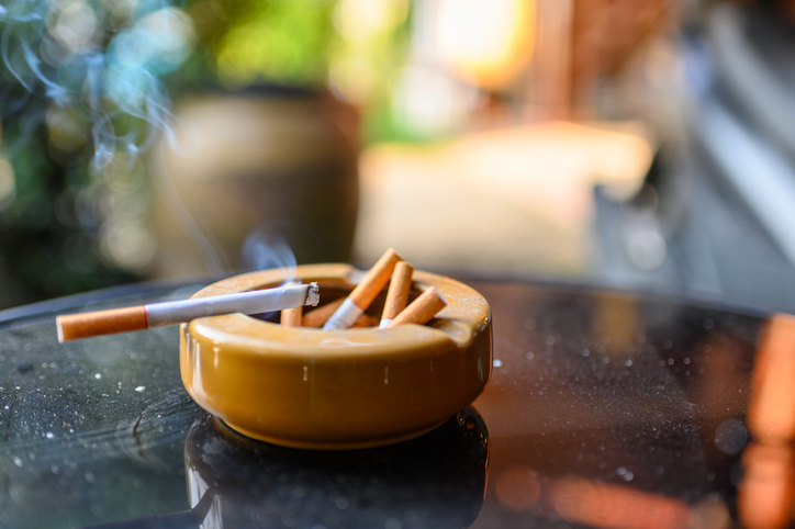 Cigarette burning with smoking on ceramic ashtray